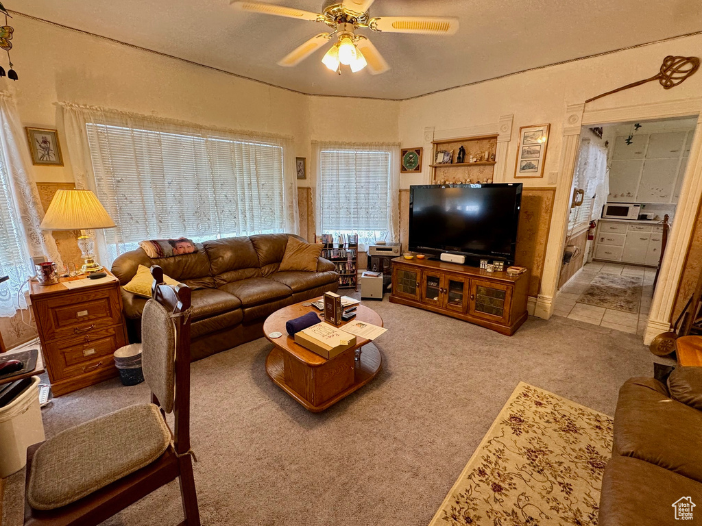 Carpeted living area with a ceiling fan