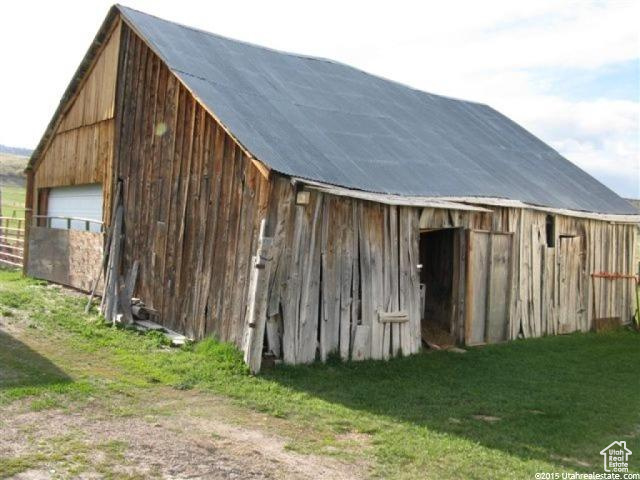 View of barn featuring a lawn