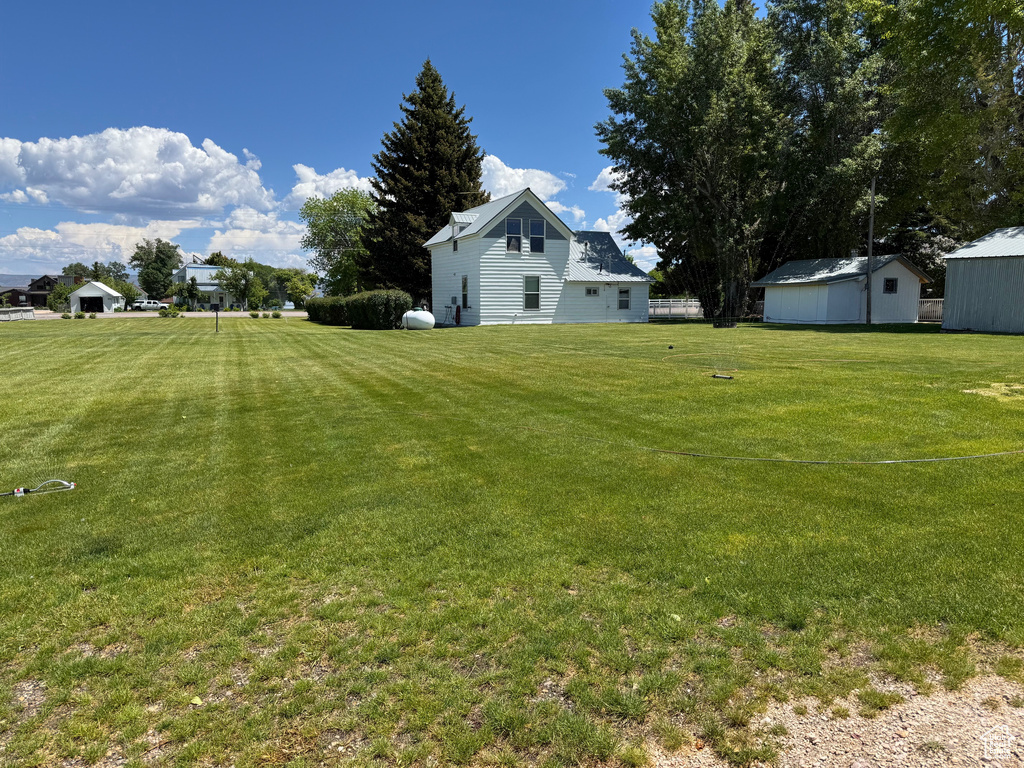 View of grassy yard with a storage shed