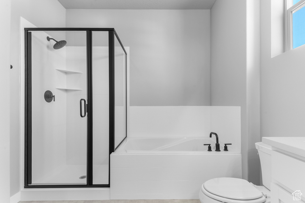 Bathroom with toilet, a garden tub, a stall shower, and vanity