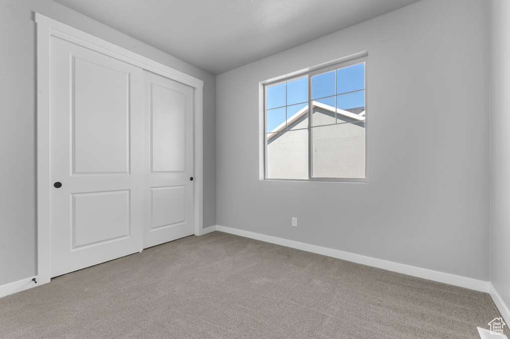 Unfurnished bedroom with baseboards and carpet floors