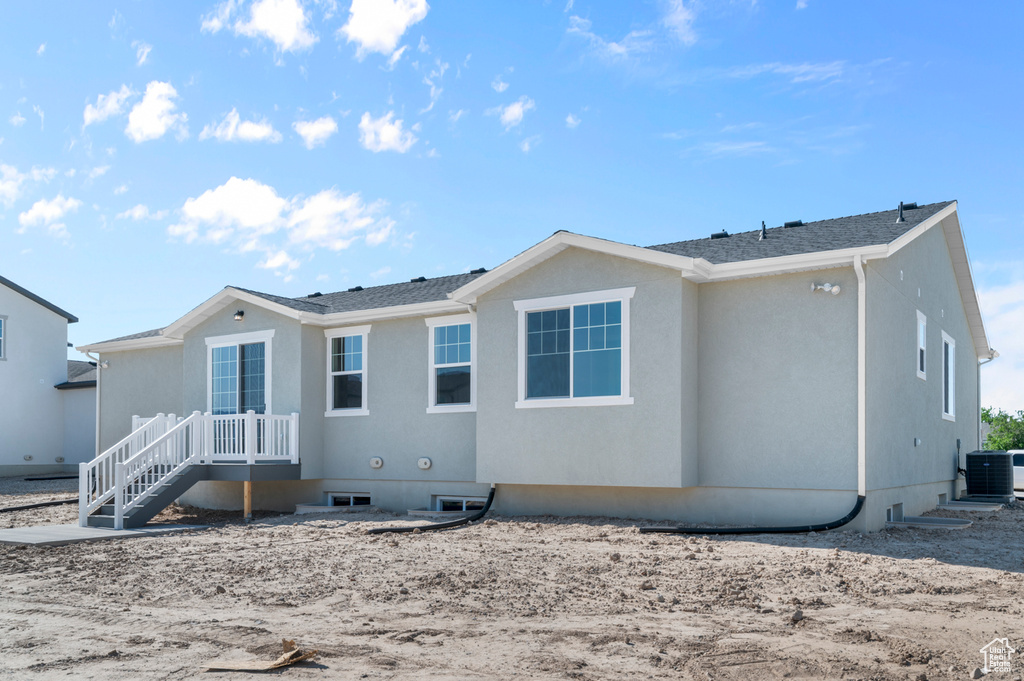 Rear view of property featuring central AC and stucco siding