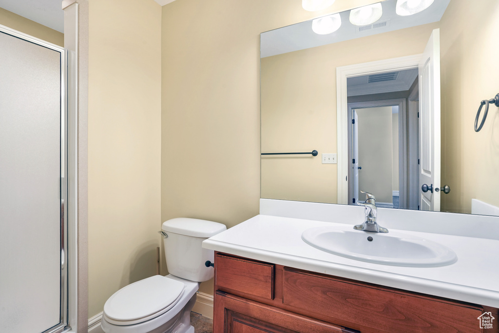 Bathroom with toilet, visible vents, a stall shower, and vanity
