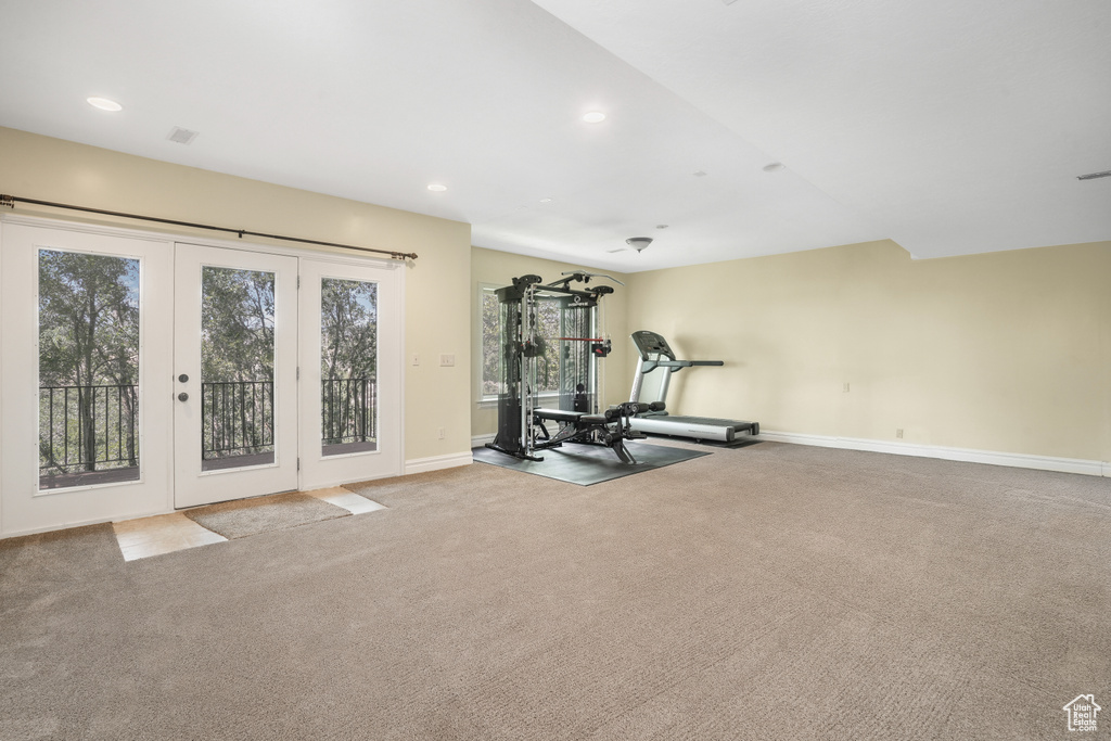 Exercise room featuring light carpet, french doors, recessed lighting, and baseboards