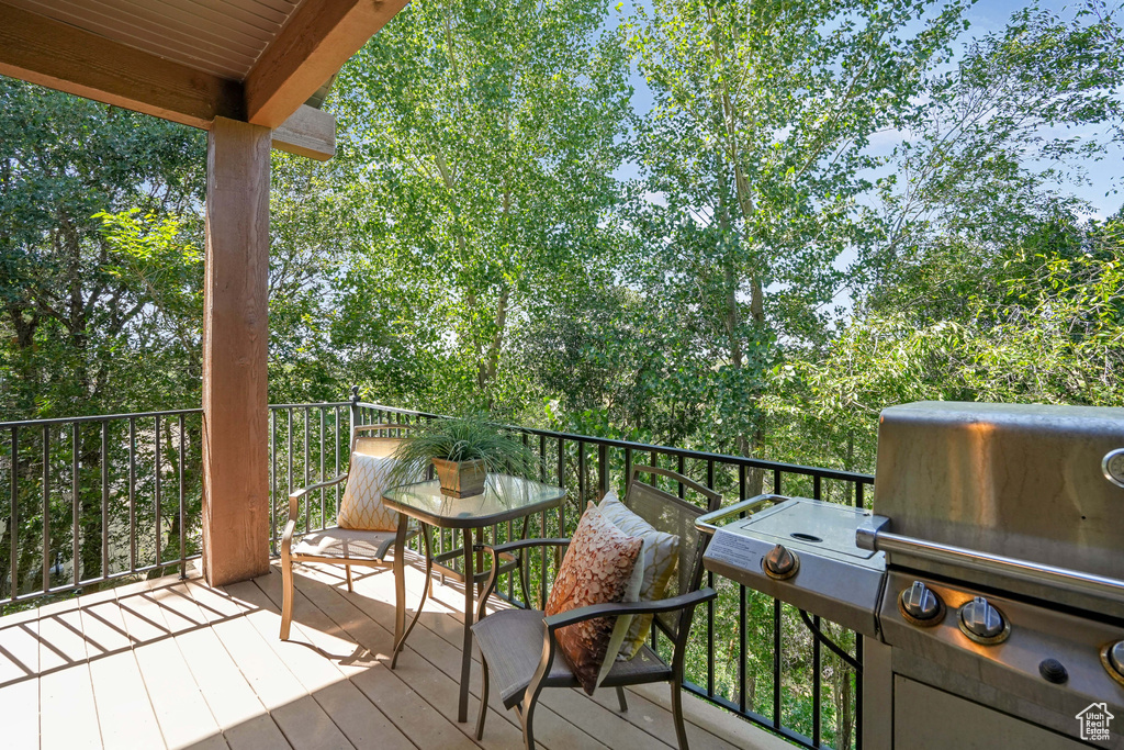 Wooden terrace featuring a grill