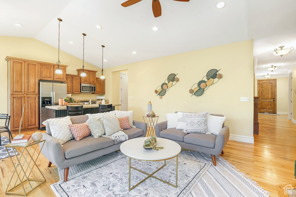 Living room with light wood-style floors, vaulted ceiling, a ceiling fan, and recessed lighting