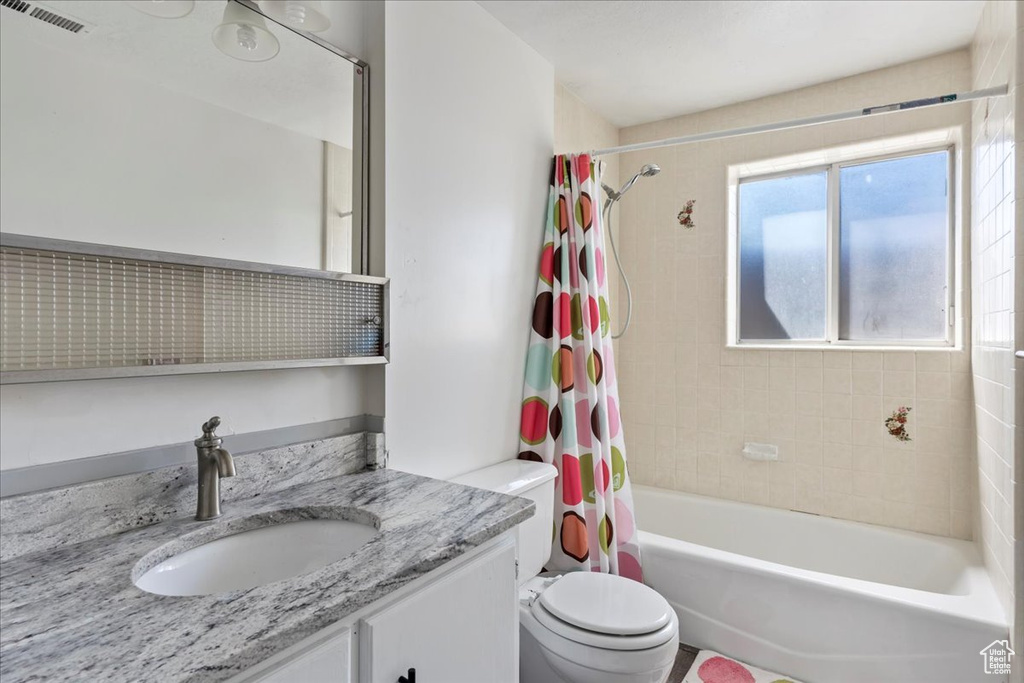 Full bath with shower / tub combo, visible vents, vanity, and toilet