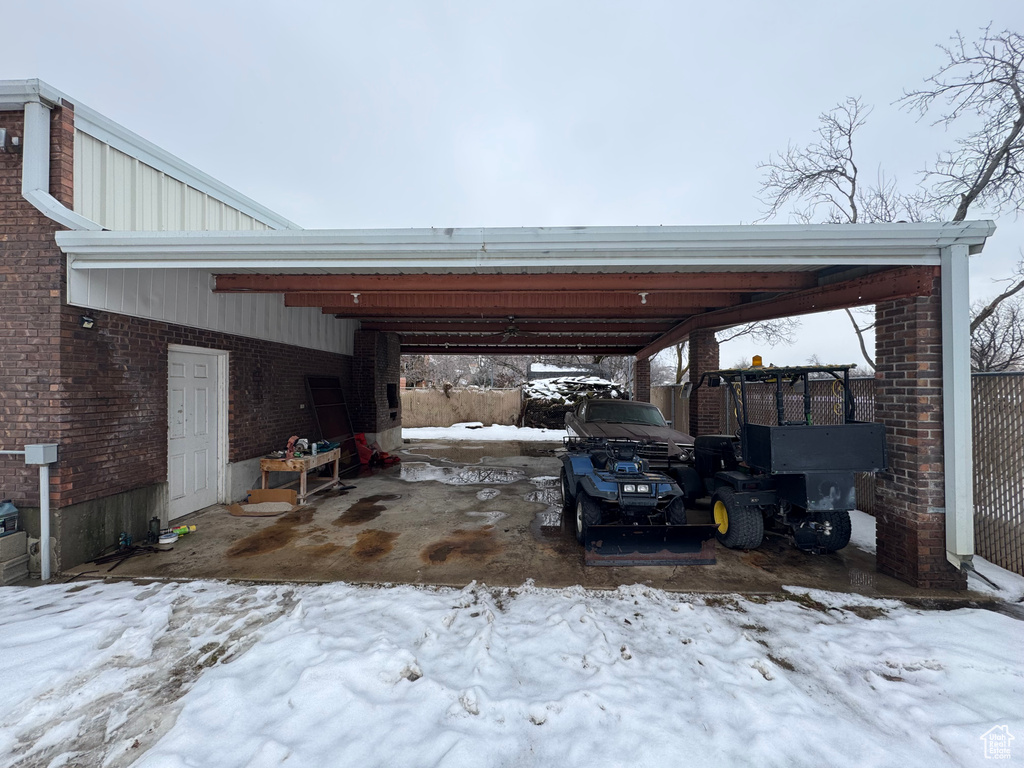 Snow covered parking with a carport
