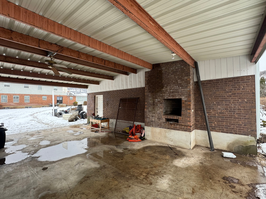 Snow covered patio featuring a fireplace and a ceiling fan