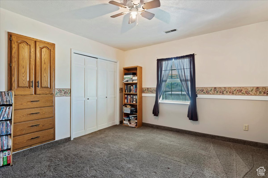 Unfurnished bedroom featuring dark colored carpet, a closet, visible vents, ceiling fan, and baseboards