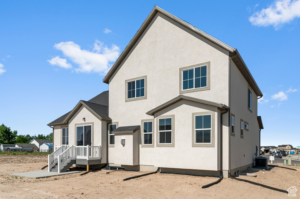 Back of house featuring stucco siding and central AC