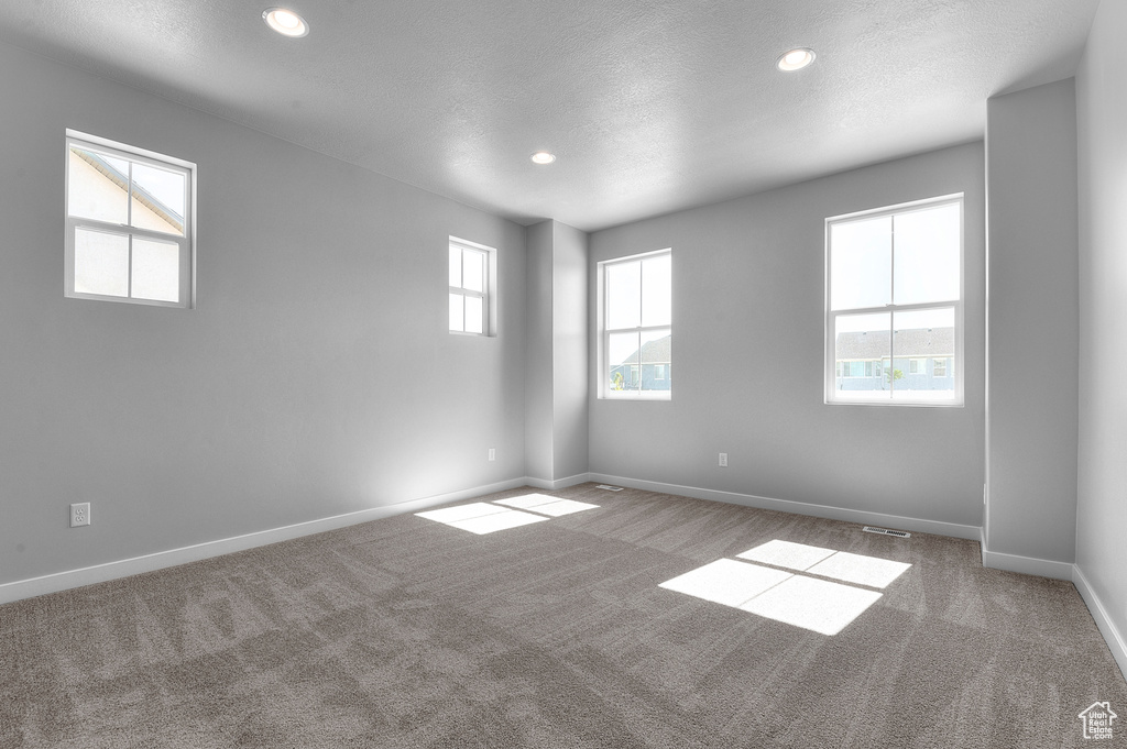 Carpeted spare room featuring baseboards, recessed lighting, and a textured ceiling