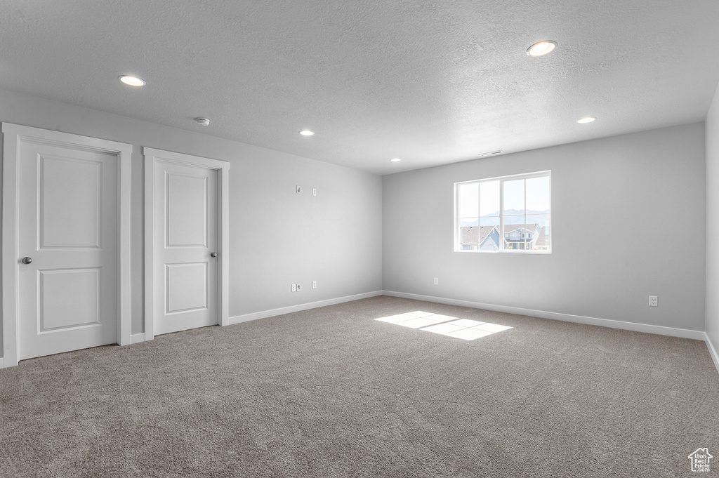 Unfurnished bedroom with carpet floors, baseboards, recessed lighting, and a textured ceiling