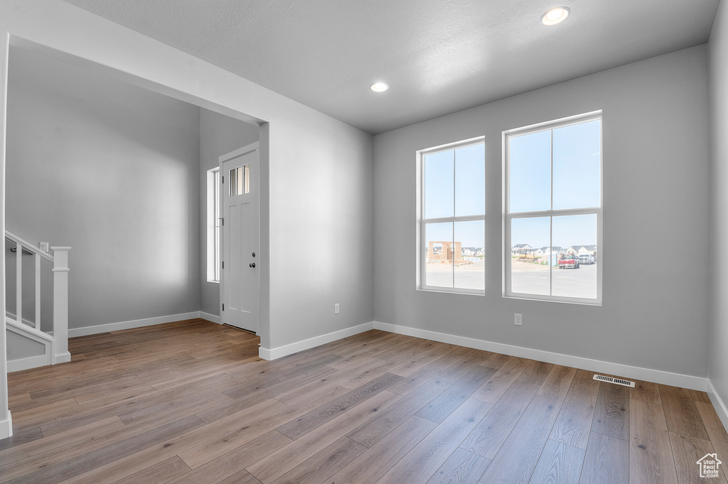 Spare room featuring healthy amount of natural light, baseboards, wood finished floors, and recessed lighting