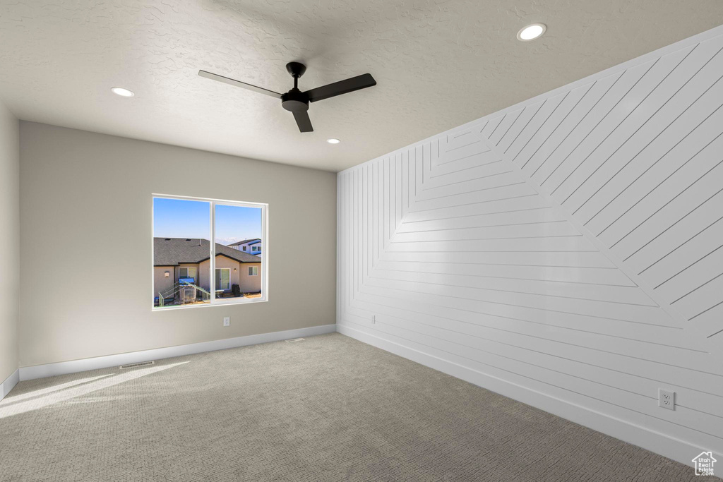 Unfurnished room featuring ceiling fan, a textured ceiling, carpet, and baseboards