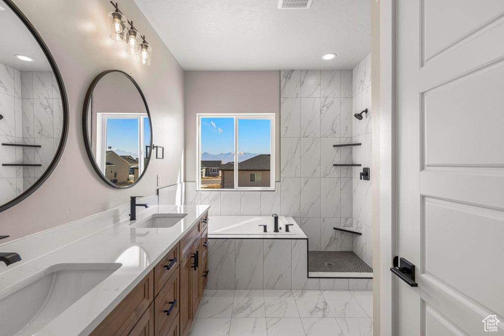 Bathroom with marble finish floor, a marble finish shower, a garden tub, and a sink