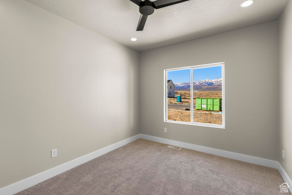 Spare room featuring carpet, recessed lighting, visible vents, a ceiling fan, and baseboards