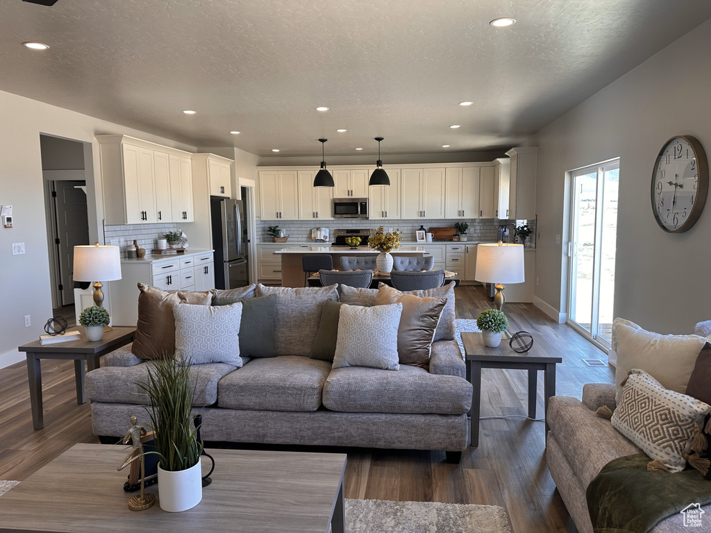 Living room with dark wood-style floors, recessed lighting, and baseboards