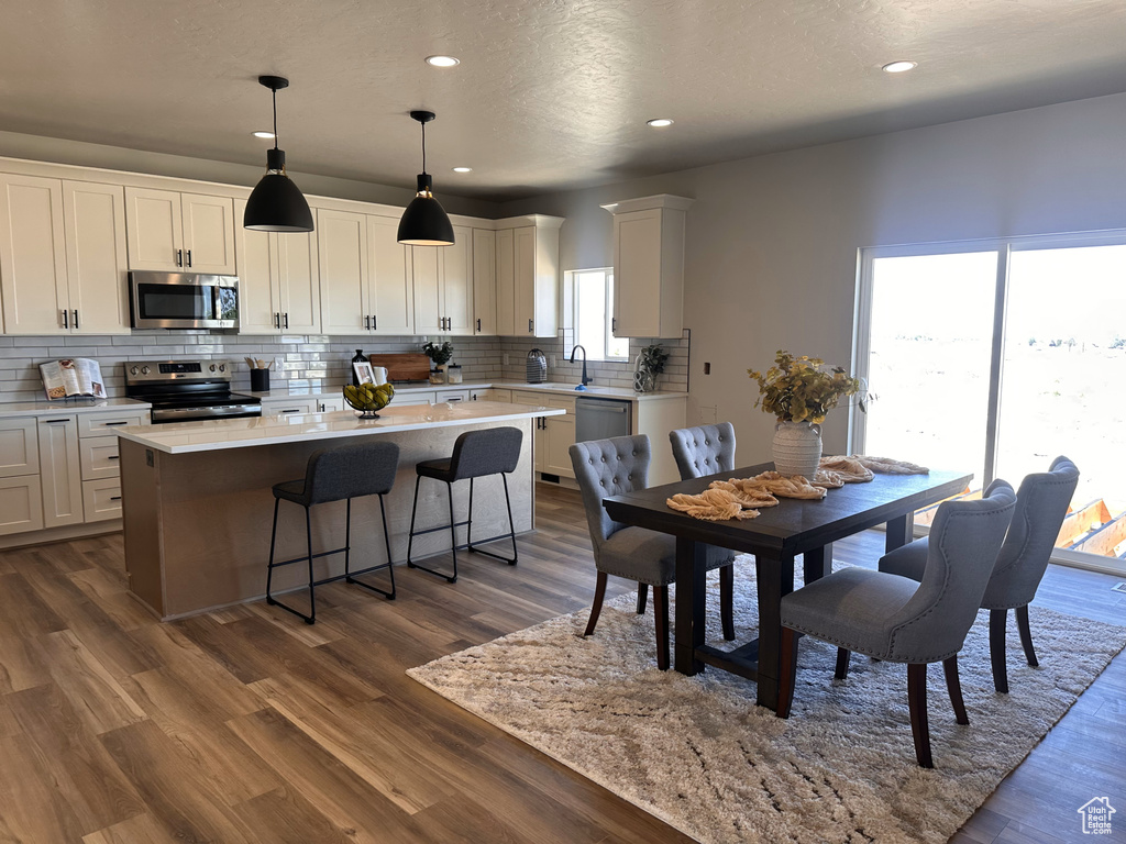 Dining room with dark wood-style floors and recessed lighting
