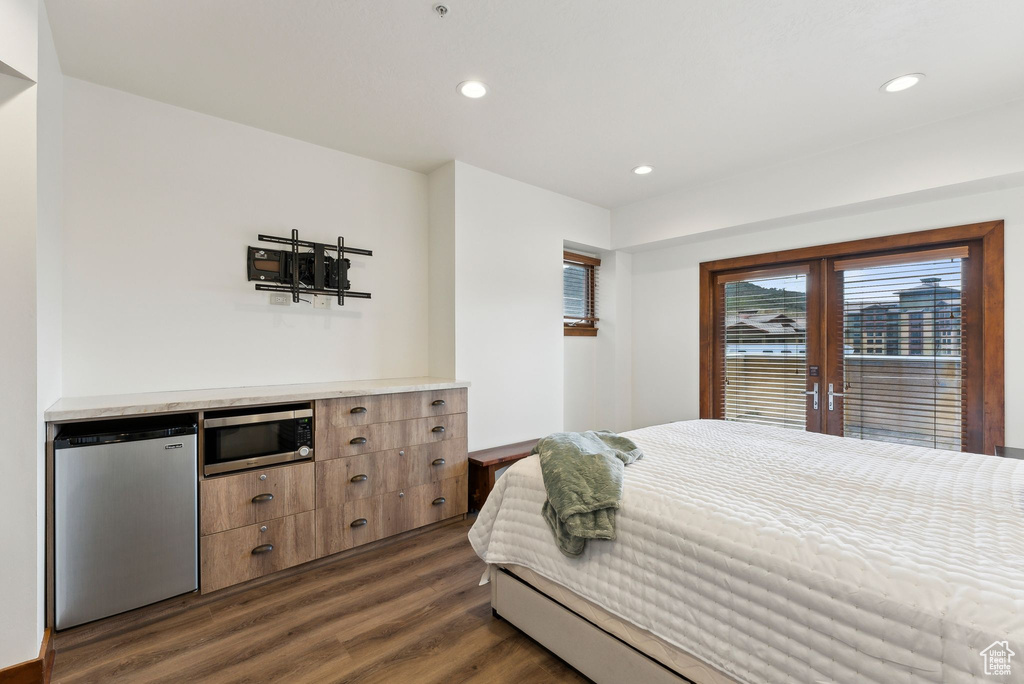 Bedroom with refrigerator, dark wood-style floors, access to outside, and recessed lighting