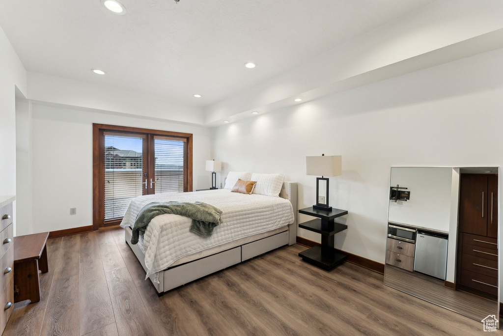 Bedroom with dark wood finished floors, baseboards, and recessed lighting