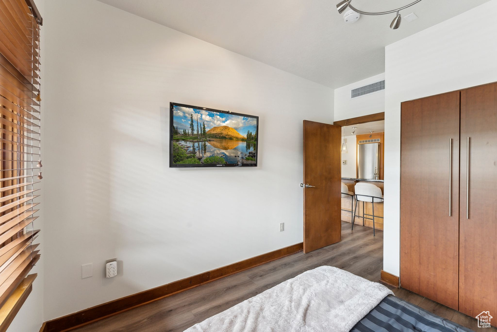 Bedroom featuring wood finished floors, baseboards, and a closet