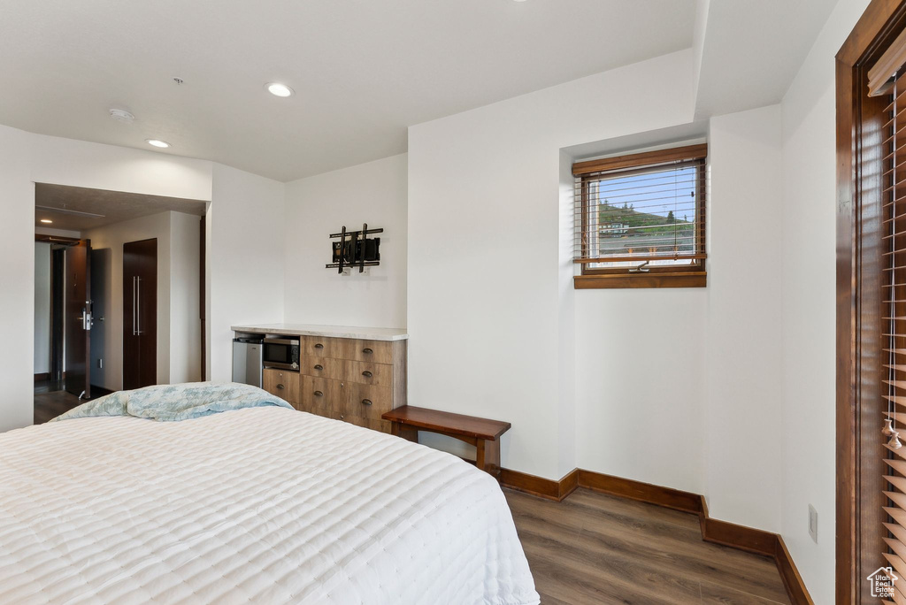 Bedroom with baseboards, dark wood-style flooring, and recessed lighting