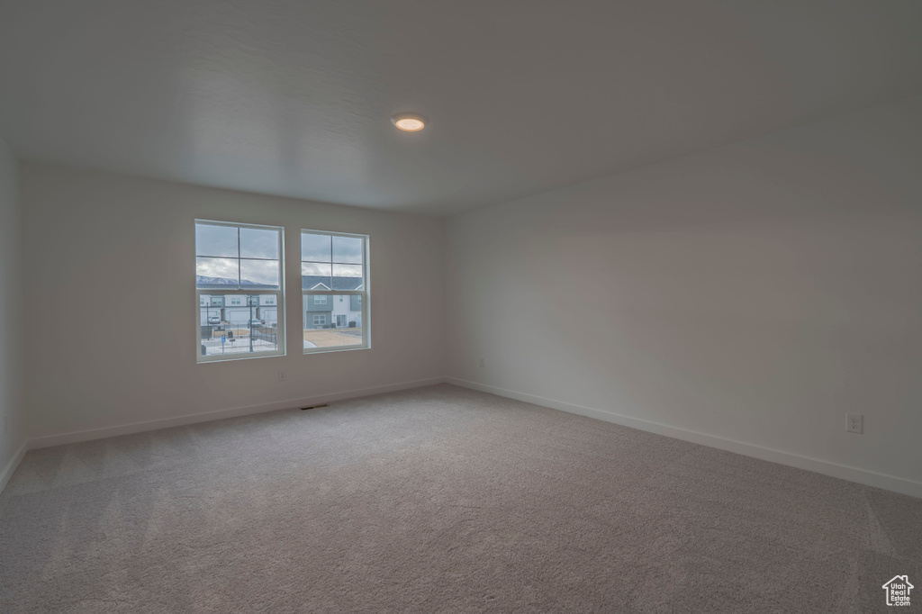 Unfurnished room with light carpet and baseboards