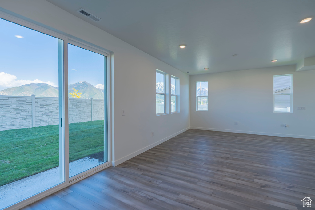 Spare room with wood finished floors, a mountain view, recessed lighting, and baseboards
