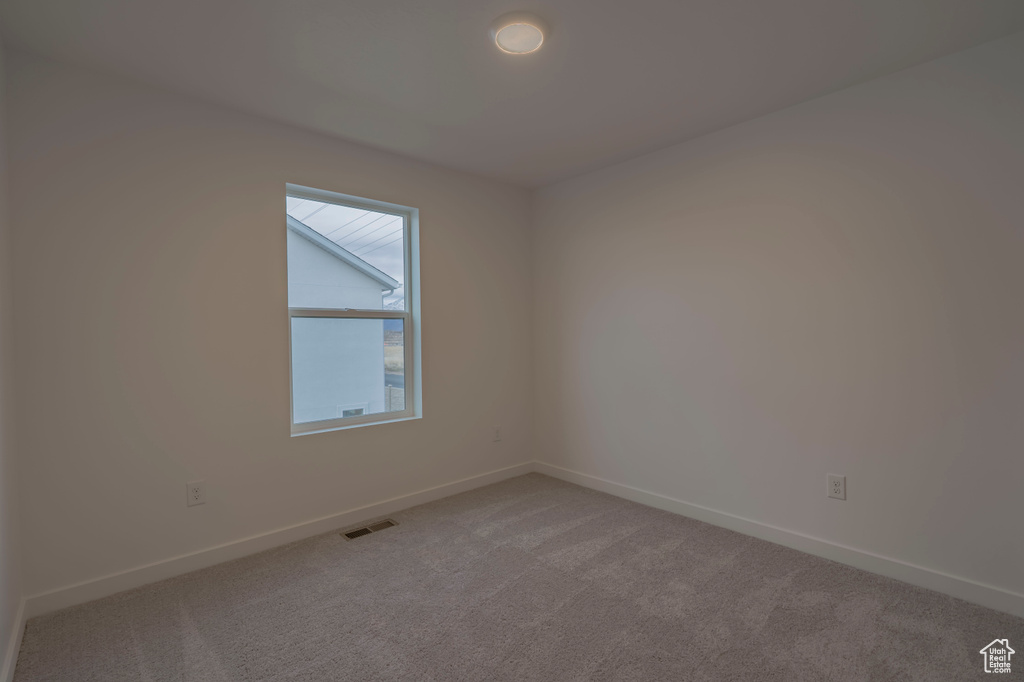 Unfurnished room with baseboards and light colored carpet