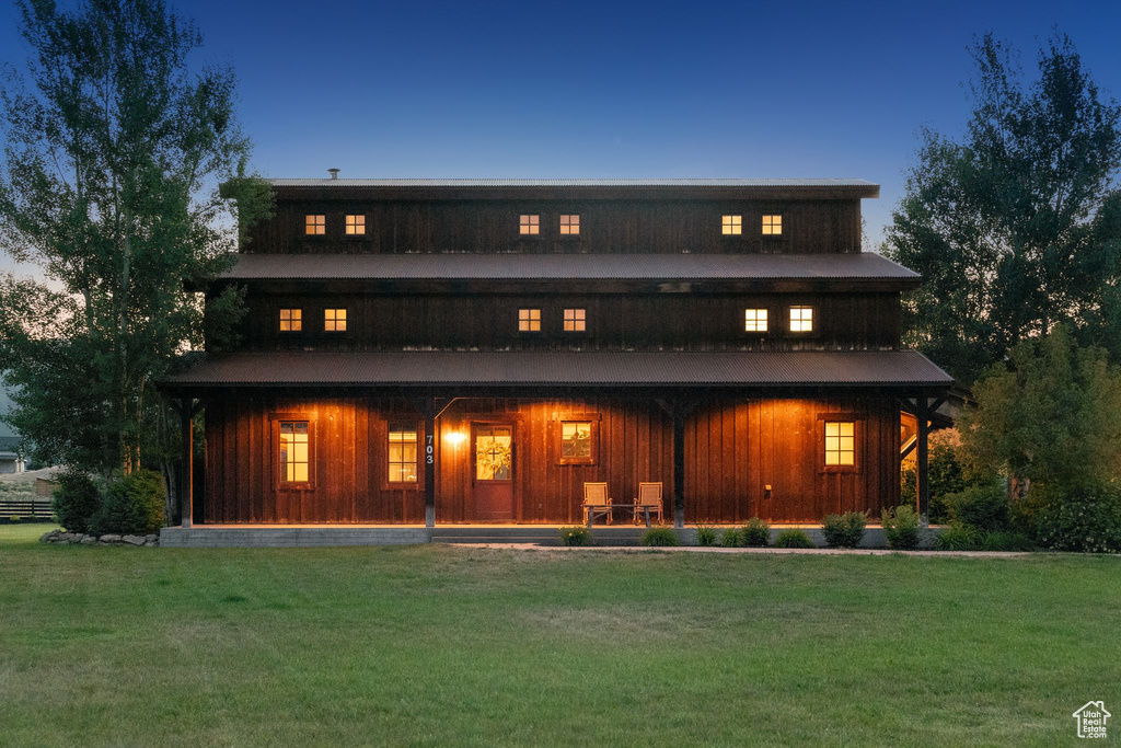 Back of house featuring a yard, a porch, and board and batten siding