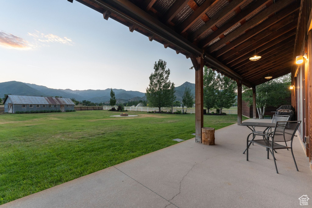 Fenced backyard featuring a mountain view and a patio