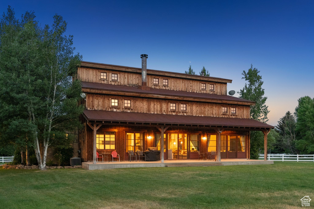 Back of house at dusk with a patio area