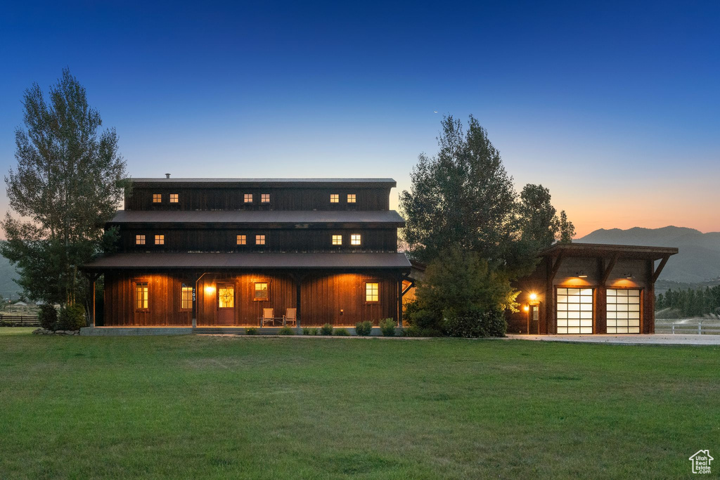 Rear view of property with a yard, a mountain view, covered porch, and board and batten siding