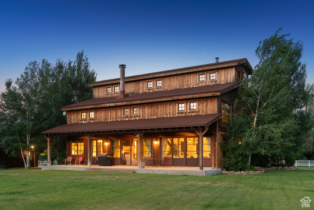 Back of house with a yard and a patio