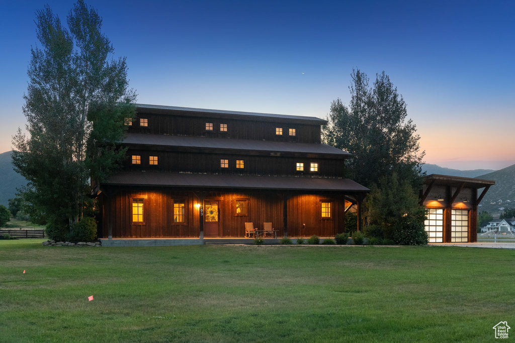 Back of property featuring a lawn, board and batten siding, and a porch