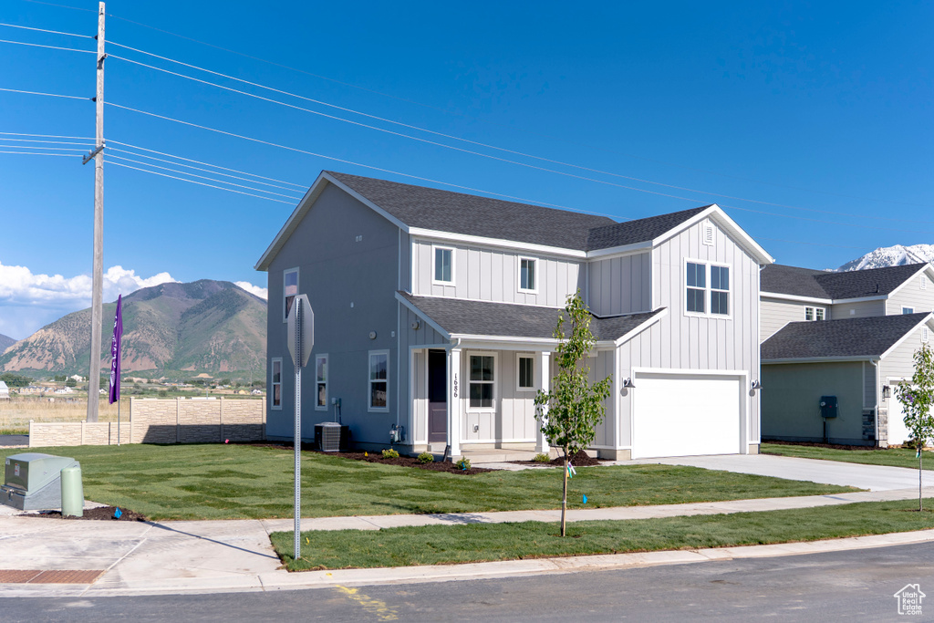 Modern inspired farmhouse featuring central air condition unit, a shingled roof, a mountain view, driveway, and a garage