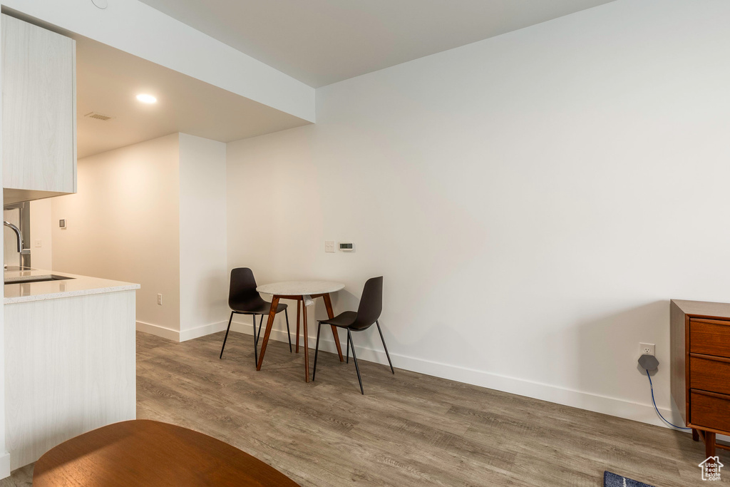 Dining space with sink and wood-type flooring
