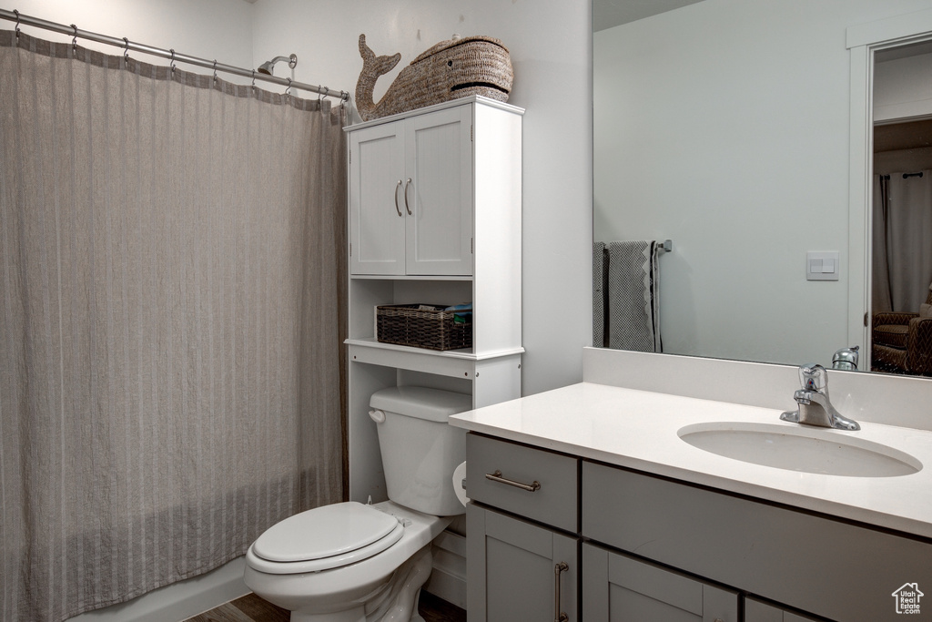Full bath featuring toilet, shower / tub combo with curtain, and vanity