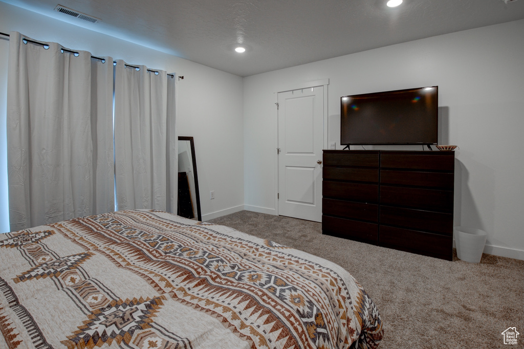 Carpeted bedroom with baseboards, visible vents, and recessed lighting