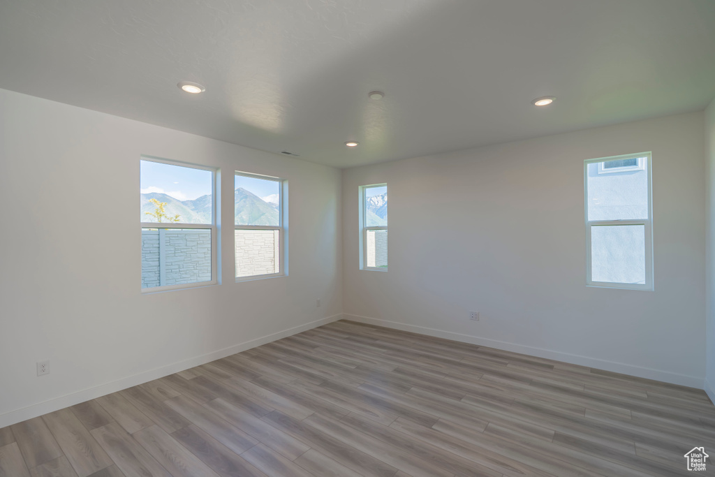 Unfurnished room featuring light wood-style floors, baseboards, and recessed lighting