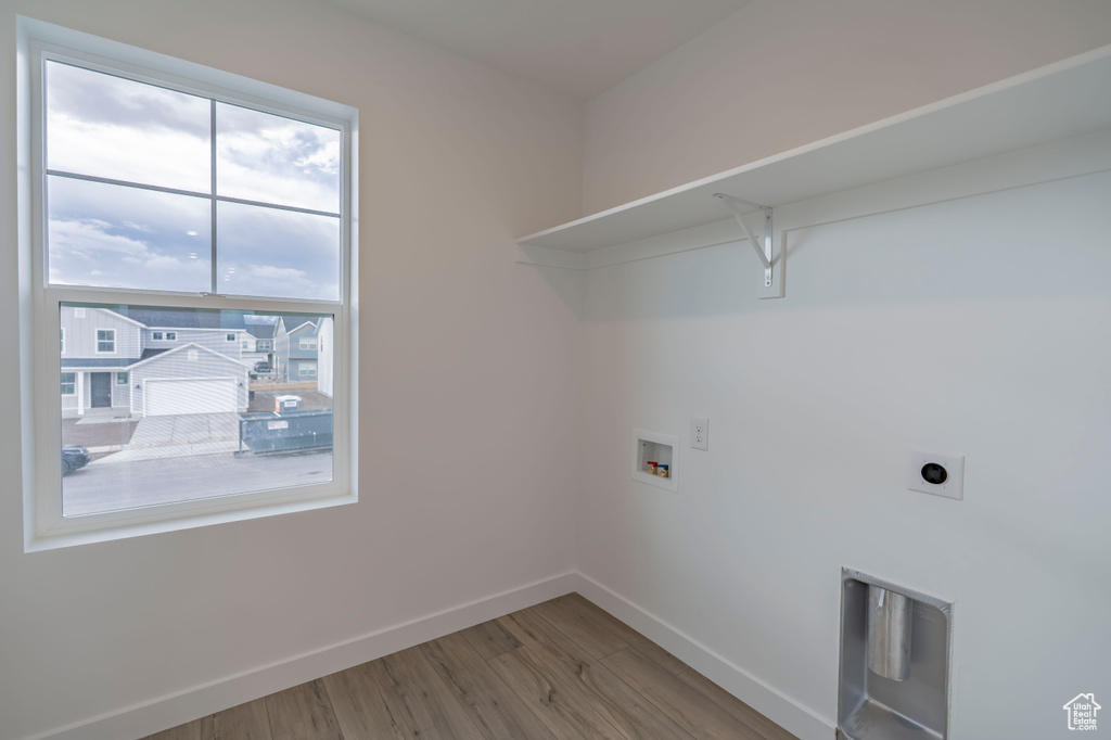 Laundry area featuring baseboards, washer hookup, wood finished floors, and hookup for an electric dryer