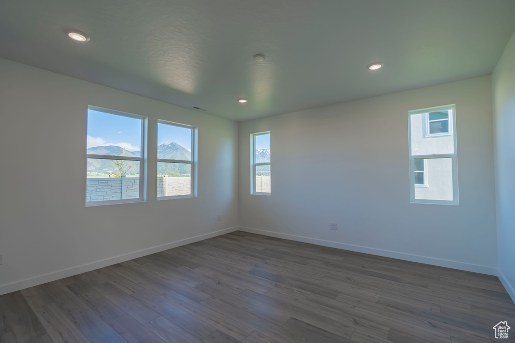 Unfurnished room featuring baseboards, dark wood-style floors, and recessed lighting