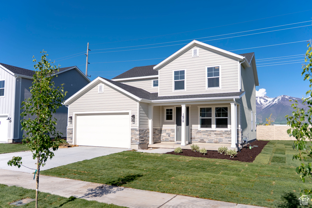 Traditional-style house with a porch, concrete driveway, an attached garage, and stone siding