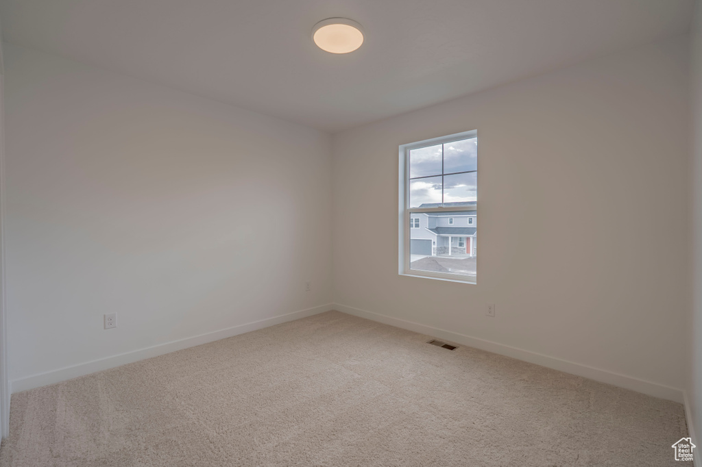 Empty room featuring carpet floors and baseboards