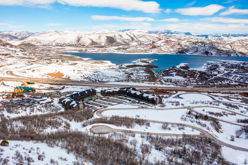 Snowy aerial view featuring a water and mountain view