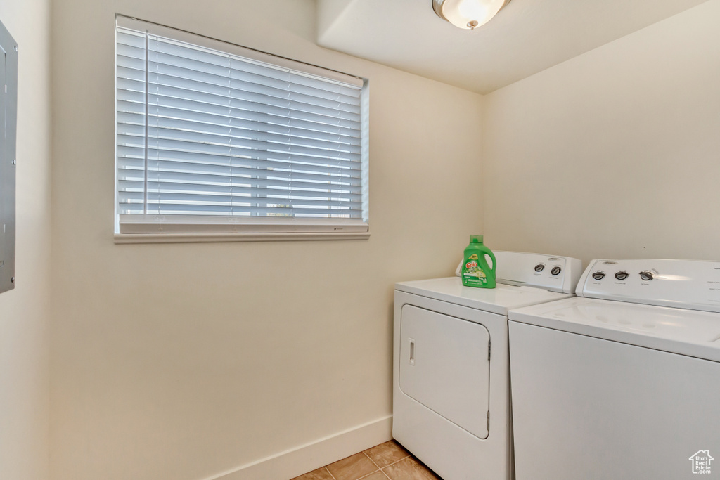 Laundry room featuring laundry area, light tile patterned floors, baseboards, and independent washer and dryer