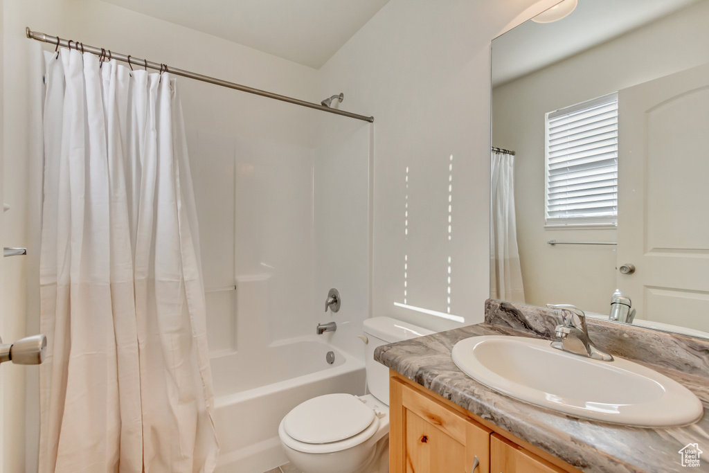 Full bathroom featuring shower / bath combo, vanity, and toilet