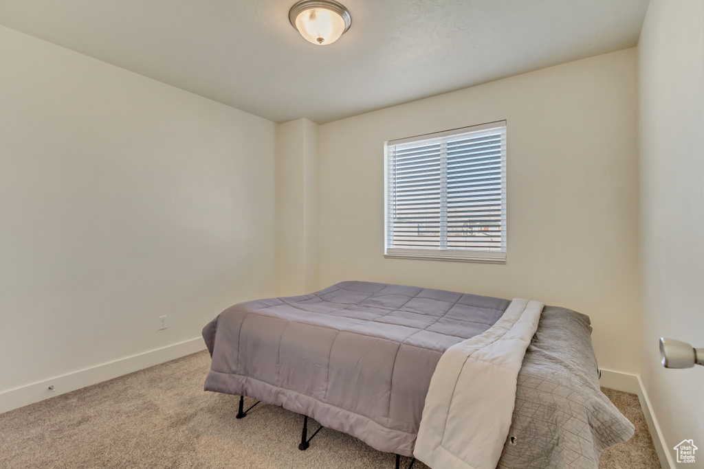 Bedroom featuring baseboards and light colored carpet