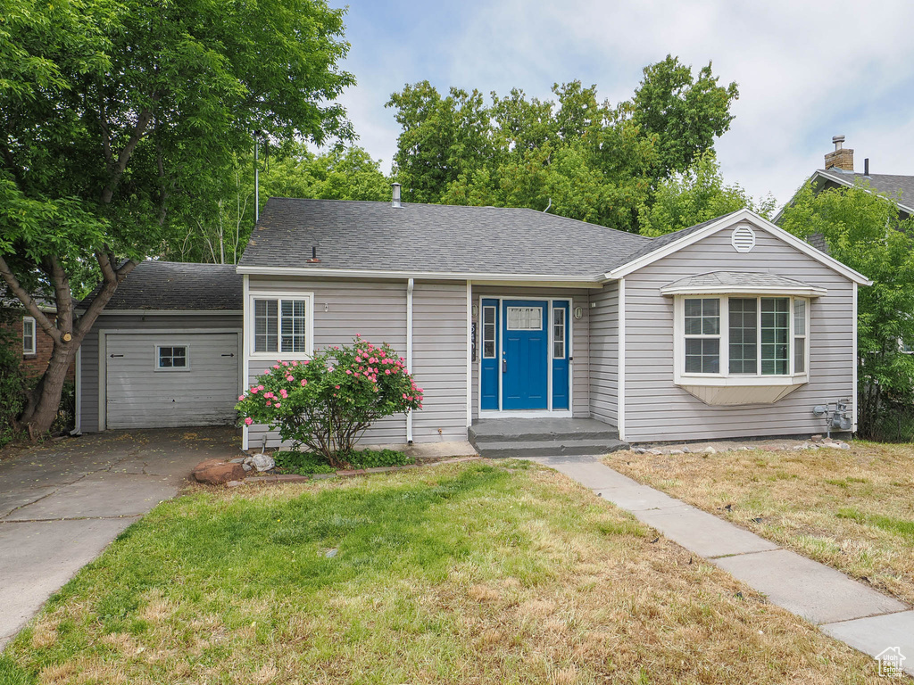 Ranch-style home with a front lawn and roof with shingles